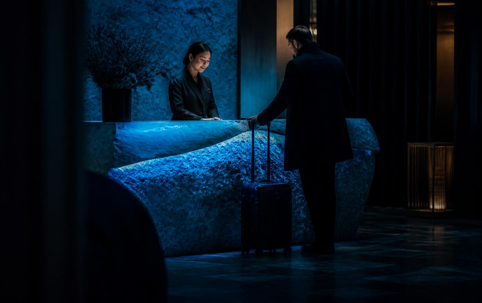 Guest checking in at a boutique hotel front desk at night
